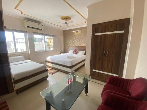 a room with two beds and a glass table in it at Hotel Sita Place On Heritage Ghats Of Benaras in Varanasi