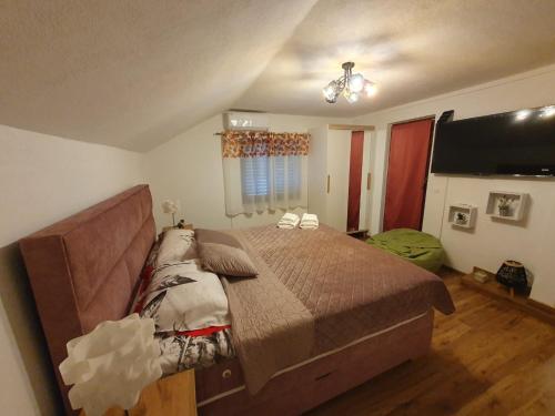 a bedroom with a large bed and a flat screen tv at Apartman Magdalena in Knin