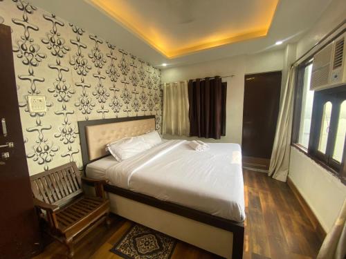 a bedroom with a bed and a wall at Hotel Sita Place On Heritage Ghats Of Benaras in Varanasi