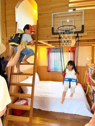 two children playing on a bunk bed with a basketball hoop at 小k柯林民宿 最多18人烤肉聚會 親子遊戲區 寵物友善 庭院 電動麻將桌 in Yilan City