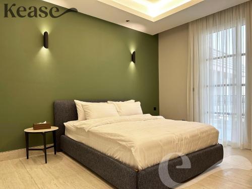 a bedroom with a bed and a green wall at Kease King Salman S-6 Lusso Najd XZ90 in Riyadh