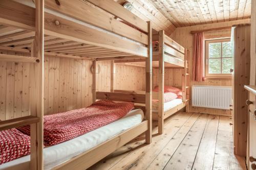 two bunk beds in a room with wooden walls at Hauserlhütte in Zederhaus