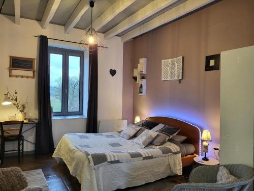 Chez Christy Chemin des Dinots في Saint-Bonnet-de-Four: غرفة نوم بسرير ونافذة كبيرة