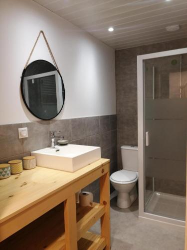 une salle de bain avec un lavabo et un miroir dans l'établissement La Petite Maison, à Saint-Claude