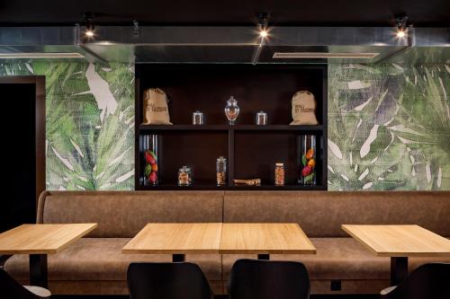 a restaurant with wooden tables and a wall with plants at Swiss Chocolate by Fassbind Lausanne in Lausanne