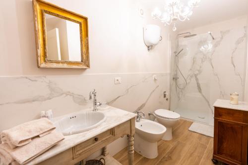 een badkamer met een wastafel, een toilet en een douche bij Casa vacanze Dentro le Mura in Gualdo Tadino
