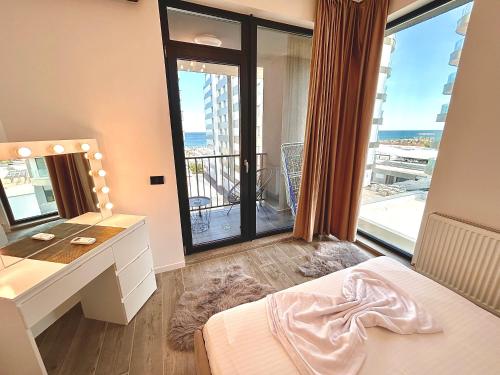 een slaapkamer met een bed en een bureau met een spiegel bij Summerland Seaview Apartments in Mamaia