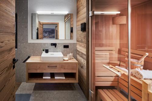 a bathroom with a sink and a mirror at Alpin Residenzen Eichenheim Aurach bei Kitzbühel by Alpina-Holiday in Aurach bei Kitzbuhel