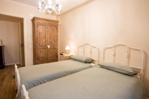 um quarto com 2 camas e um lustre em Casa vacanze Dentro le Mura em Gualdo Tadino