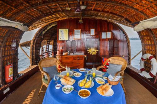 a table on a boat with food on it at Spice Coast Cruises - Houseboat, A CGH Earth Experience in Alleppey