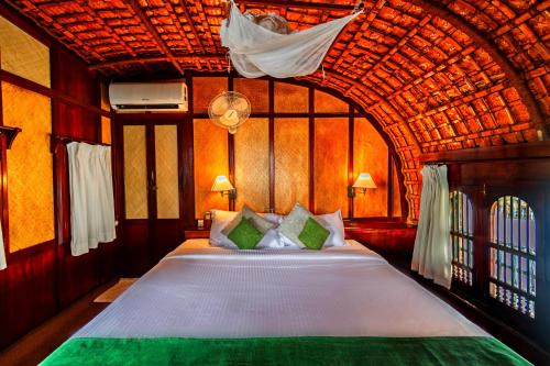 a bedroom with a large bed with a wooden ceiling at Spice Coast Cruises - Houseboat in Alleppey