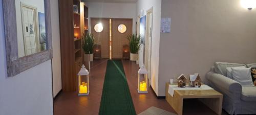 a living room with a green hallway with a couch at Life Hotels Des Alpes in Folgaria