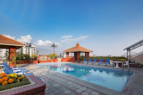 加德滿都的住宿－加德滿都麗筠酒店，一个带椅子的游泳池和一个凉亭