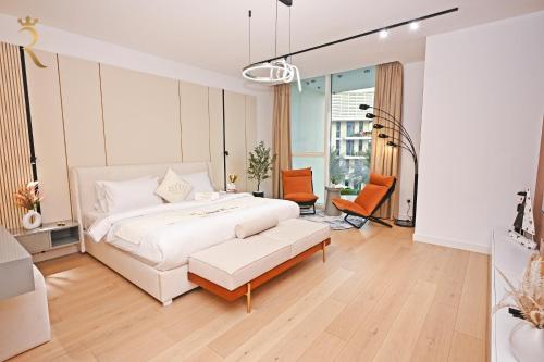 una camera bianca con un letto e una sedia di Sandy 1BR Soul Beach Mamsha Al Saadiyat Island a Abu Dhabi