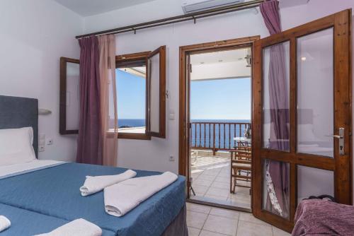 Galini Apartments في لينتاس: غرفة نوم مع سرير وإطلالة على المحيط