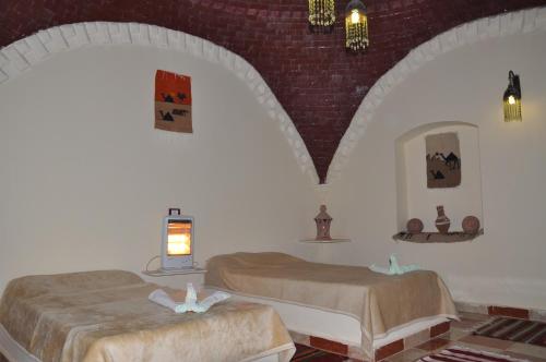 a bedroom with two beds in a room at Oasis Panorama Hotel in Bawiti