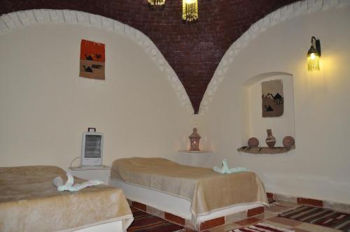 a bedroom with two beds in a room at Oasis Panorama Hotel in Bawiti