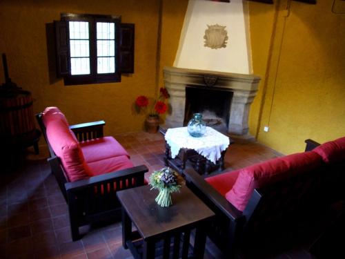salon z czerwonymi meblami i kominkiem w obiekcie Can Marc w mieście Dosríus