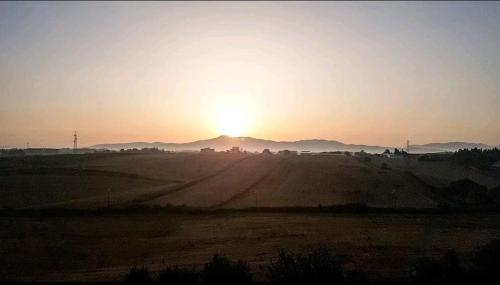 a sunset over a field with the sun in the sky at wanderlust in Pomezia