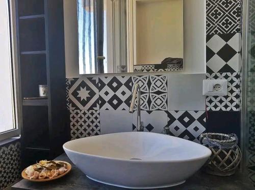 a white tub in a bathroom with black and white tiles at wanderlust in Pomezia