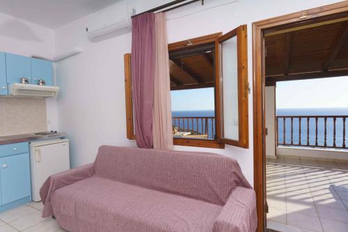 a living room with a couch and a balcony at Galini Apartments in Léntas