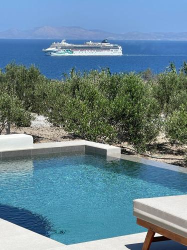 a swimming pool with a cruise ship in the water at Saint John Oia-Private Heated Pool Villas in Oia