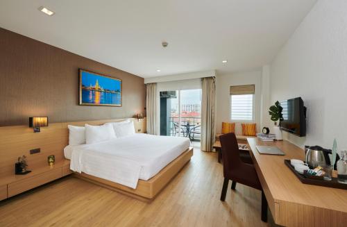 芭達雅中心的住宿－Adelphi Pattaya - SHA Extra Plus，酒店客房配有一张床和一张带电脑的书桌