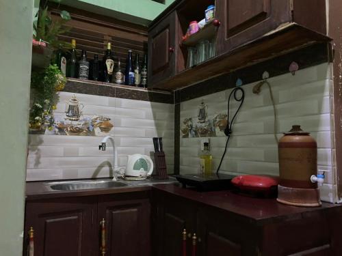 a kitchen with a sink and a counter with bottles at Serene Garden Lodge in Ahangama