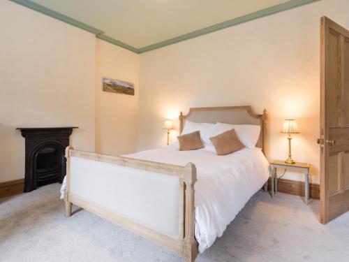 a bedroom with a bed with white sheets and a fireplace at 3 Bed in Keswick SZ030 in Keswick