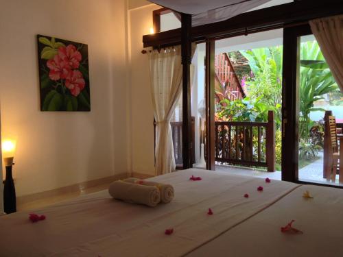 a bedroom with a bed with flowers on the floor at Rumah Cahaya in Gili Trawangan