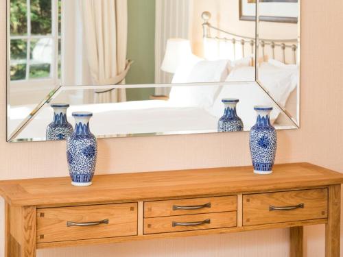 three blue vases on a wooden dresser in front of a mirror at 3 Bed in Applethwaite SZ168 in Applethwaite