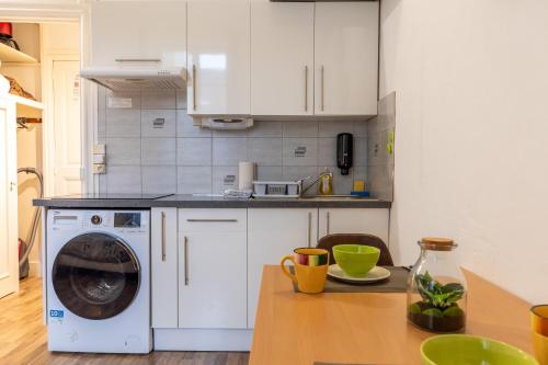 a kitchen with a washing machine on a table at Résidence du Parc appartement calme in Châtel-Guyon
