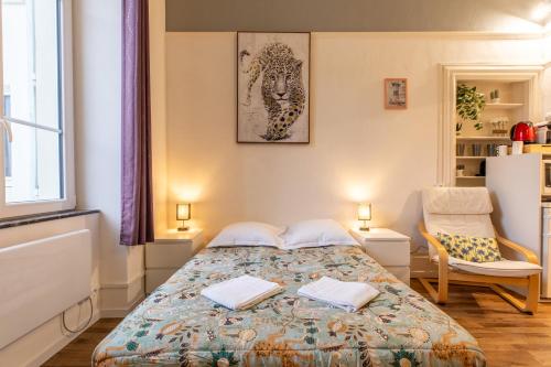 um pequeno quarto com uma cama e uma cadeira em Résidence du Parc appartement calme em Châtel-Guyon