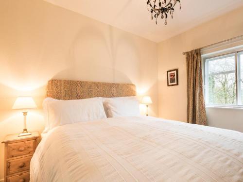 a bedroom with a large white bed with a chandelier at 2 Bed in Bassenthwaite SZ381 in Bassenthwaite Lake