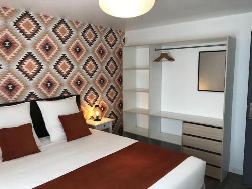 um quarto com uma cama branca e uma parede em Gîte Un air de Bicoque em Dives-sur-Mer