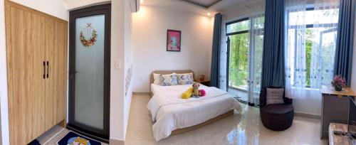 a bedroom with a bed and a large window at LA GAI HOMESTAY HOI AN in Hoi An