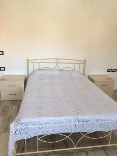 a bedroom with a bed with a white bedspread on it at Villa lake ohrid in Pogradec