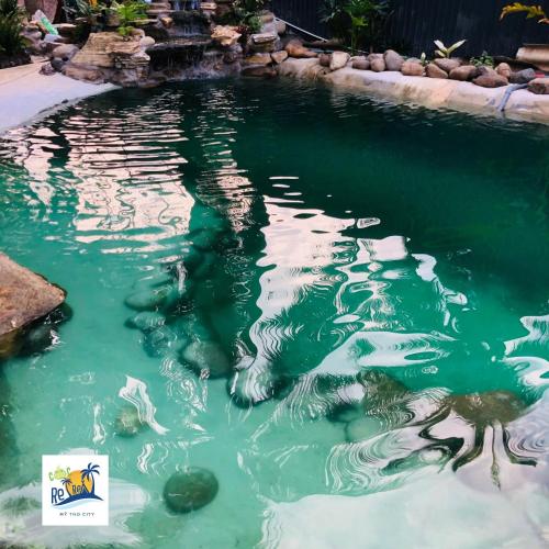 a pool of green water with rocks in it at Cóc Retreat Mỹ Tho City in My Tho