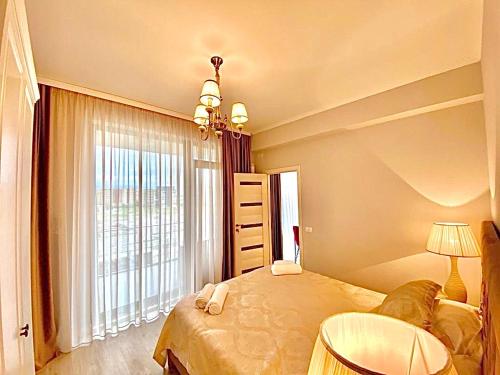 a bedroom with a bed and a large window at Summerland Seaview Apartments in Mamaia
