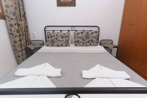 a bedroom with a bed with two white towels on it at Galini Apartments in Léntas