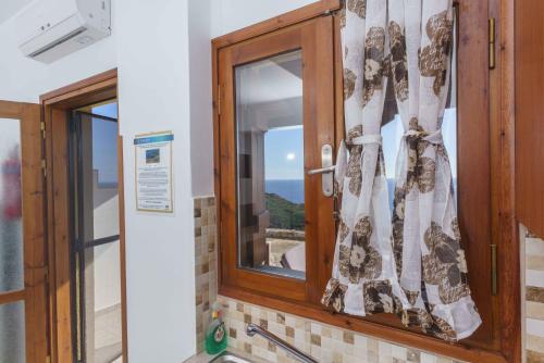 a window in a room with a view of the ocean at Galini Apartments in Léntas