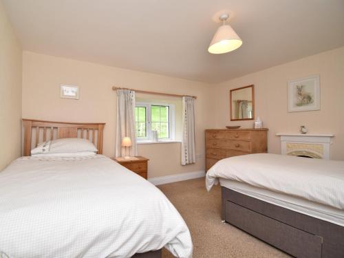 a bedroom with two beds and a fireplace at 3 Bed in Newlands Valley SZ075 in Borrowdale