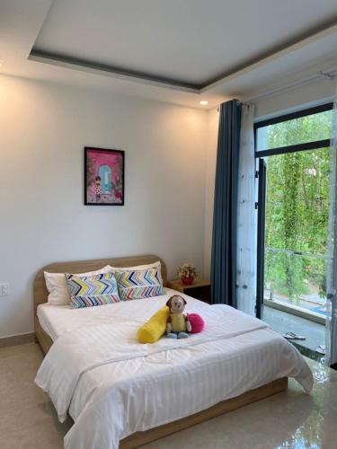 a teddy bear sitting on a bed in a bedroom at LA GAI HOMESTAY HOI AN in Hoi An