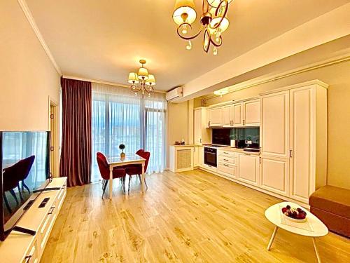 ein großes Wohnzimmer mit einem Tisch und einer Küche in der Unterkunft Summerland Seaview Apartments in Mamaia