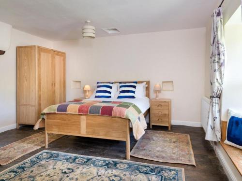 a bedroom with a bed with blue and white pillows at 2 Bed in Bampton SZ271 in Bampton