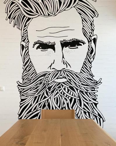 a wall mural of a man with a beard at Boutique Aparthotel Chalets Coburg in Schladming