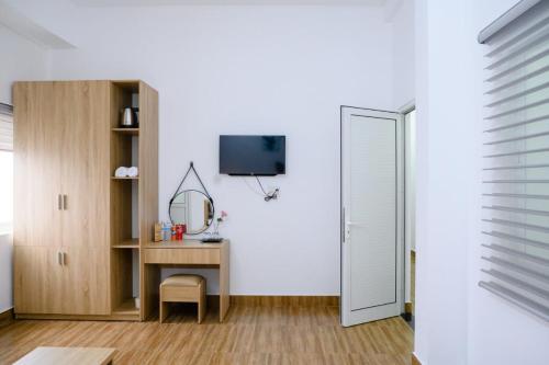 a room with a desk and a tv and a mirror at Familia Hotel in Hue