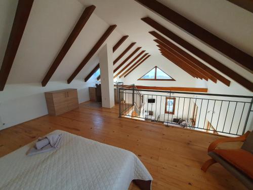 an attic room with a bed and a balcony at Árvalányhaj Vendégház in Balatonakali