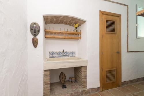 a fireplace in a white wall with a wooden door at Flamenco Soul in Chiclana de la Frontera