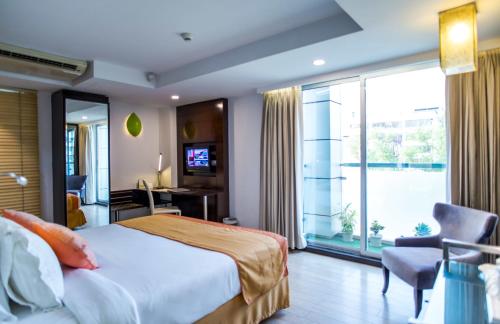ダッカにあるプラチナム レジデンスのベッドと大きな窓が備わるホテルルームです。